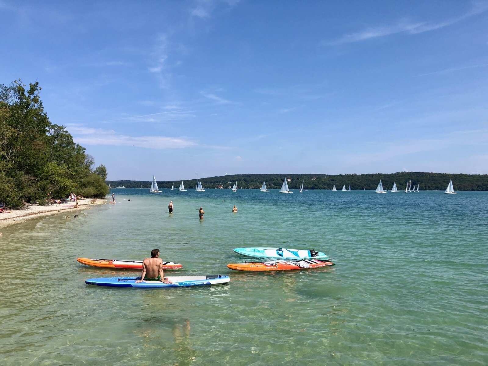 SUP Boards am Strand mit Segelbooten auf dem Starnberger See