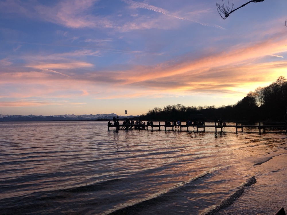 Steg bei Abendrot mit rosa Wolken über dem See