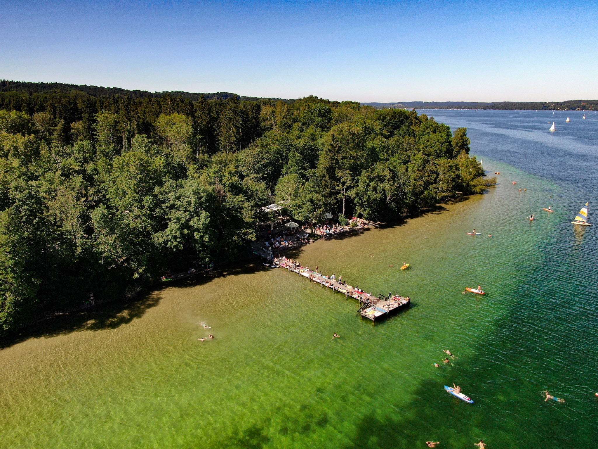 Steg 1 von oben mit Badenden und Stand-Up Paddlern im türkisen Wasser