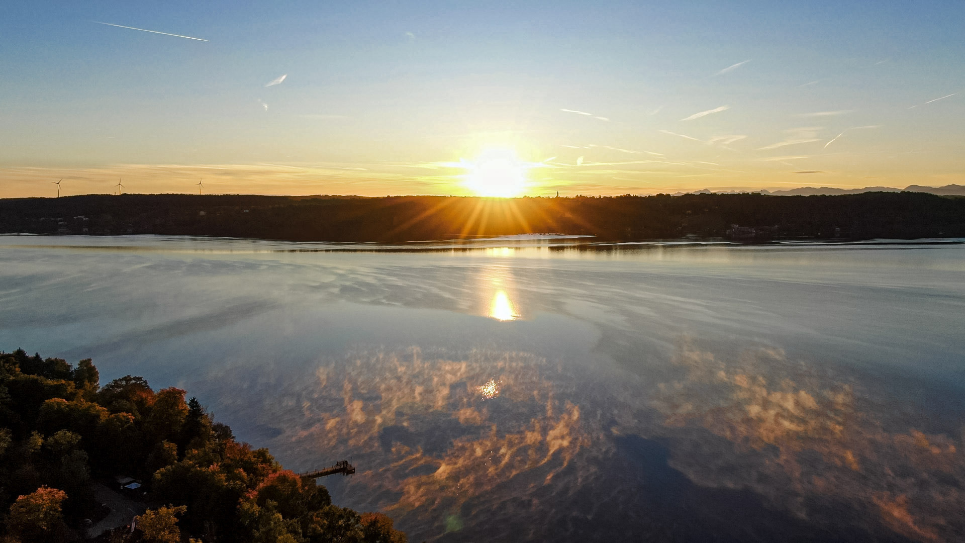 Drohnenaufnahme des Sonnenuntergangs mit Wolken-Spiegelung im Starnberger See