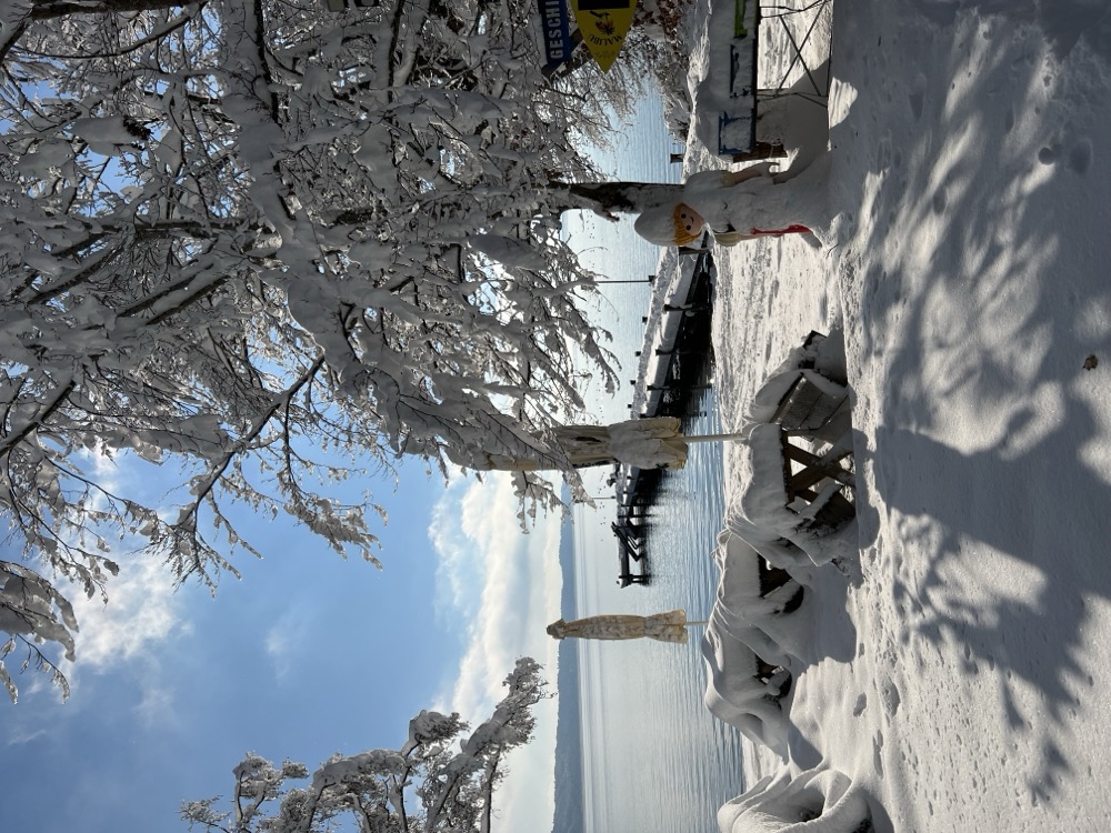 Verschneiter Biergarten mit Bänken unter Schneedecke
