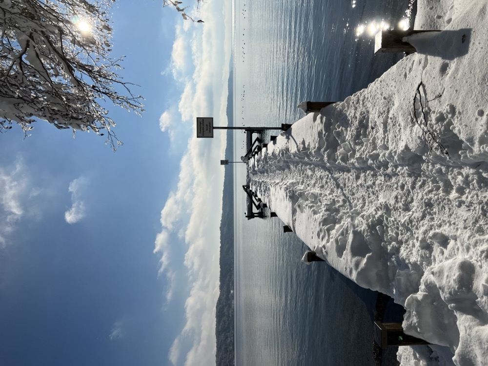 Verschneiter Weg zum Steg durch Winterlandschaft